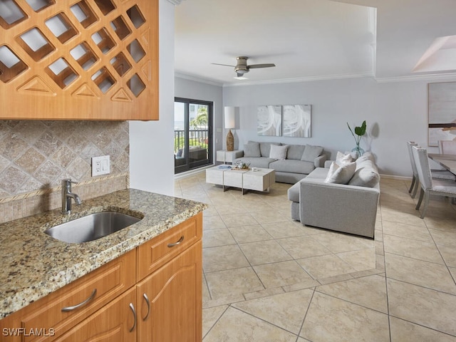 living room featuring sink, light tile patterned floors, ornamental molding, and ceiling fan