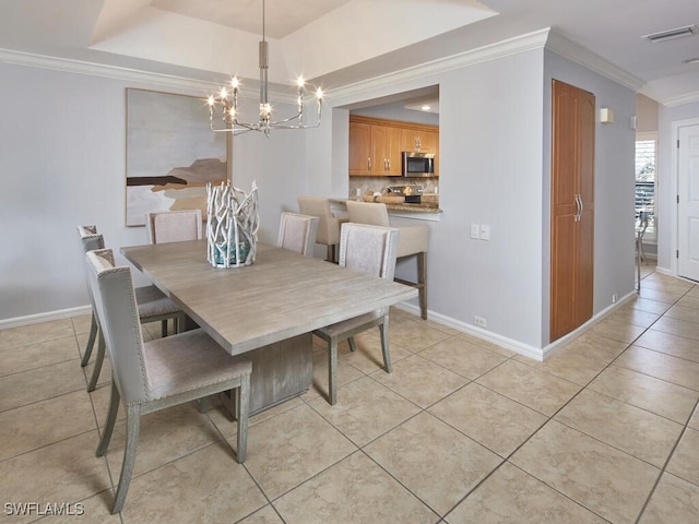 dining area featuring light tile patterned floors, ornamental molding, a raised ceiling, and a chandelier