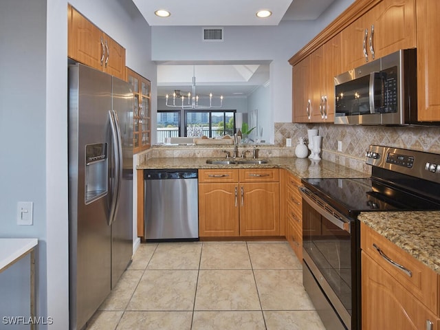 kitchen featuring light tile patterned flooring, appliances with stainless steel finishes, sink, and a notable chandelier