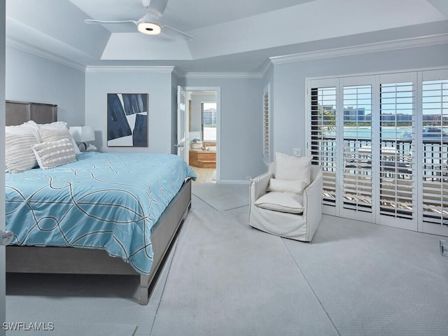 carpeted bedroom with multiple windows, a raised ceiling, ceiling fan, and ensuite bathroom