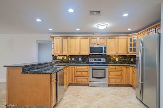 kitchen with stainless steel appliances, visible vents, glass insert cabinets, a sink, and a peninsula