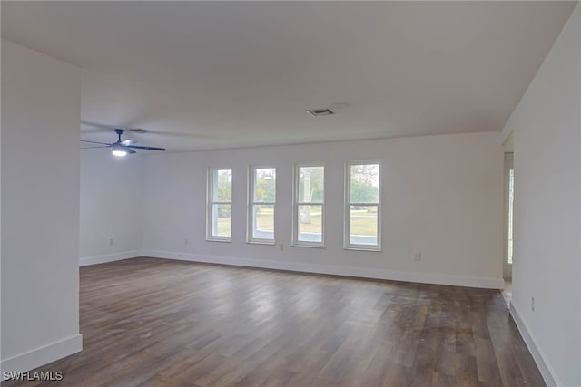 spare room with a ceiling fan, dark wood-style flooring, and baseboards