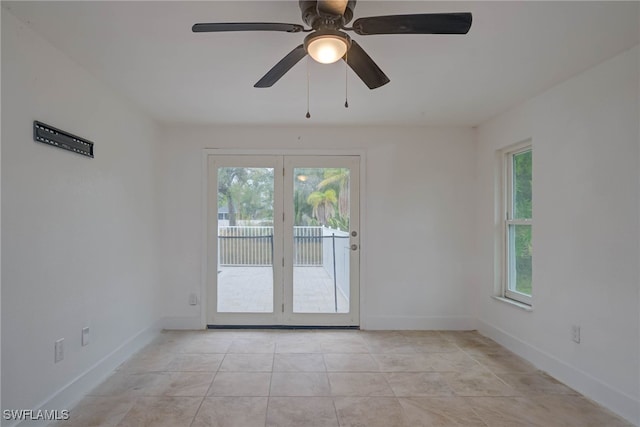 spare room with ceiling fan, baseboards, and light tile patterned floors