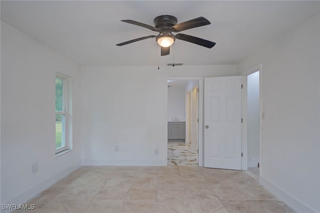 empty room with baseboards, visible vents, and a ceiling fan