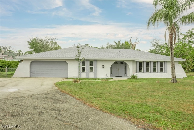 ranch-style home with an attached garage, aphalt driveway, a front lawn, and stucco siding