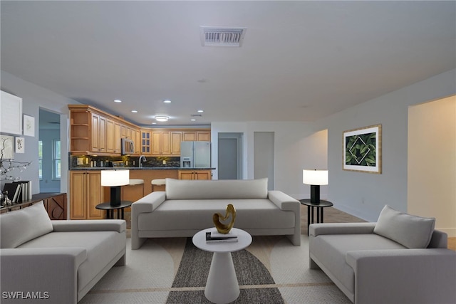 living room featuring light carpet, visible vents, and recessed lighting