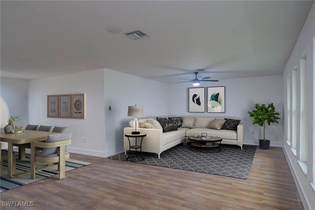 living room featuring ceiling fan, dark wood-style flooring, visible vents, and baseboards