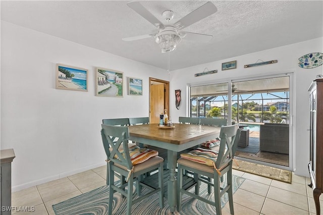 tiled dining area with a textured ceiling and ceiling fan