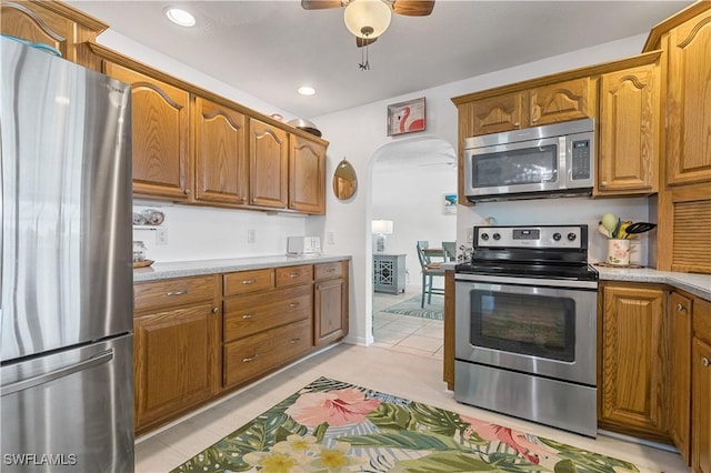 kitchen featuring light tile patterned floors, ceiling fan, and appliances with stainless steel finishes