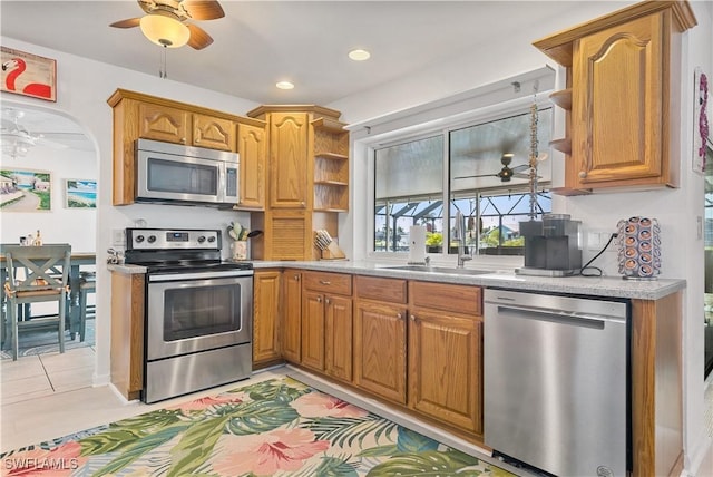 kitchen featuring sink, light tile patterned flooring, ceiling fan, and appliances with stainless steel finishes