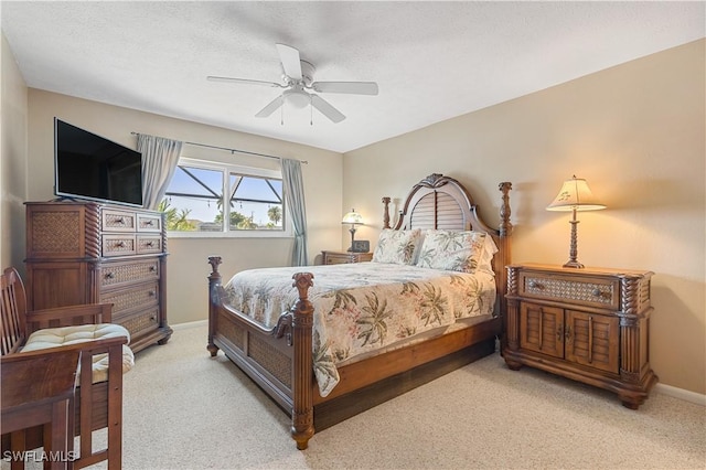 carpeted bedroom featuring ceiling fan and a textured ceiling