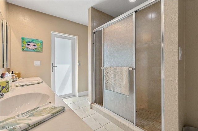 bathroom featuring a shower with door, vanity, and tile patterned floors