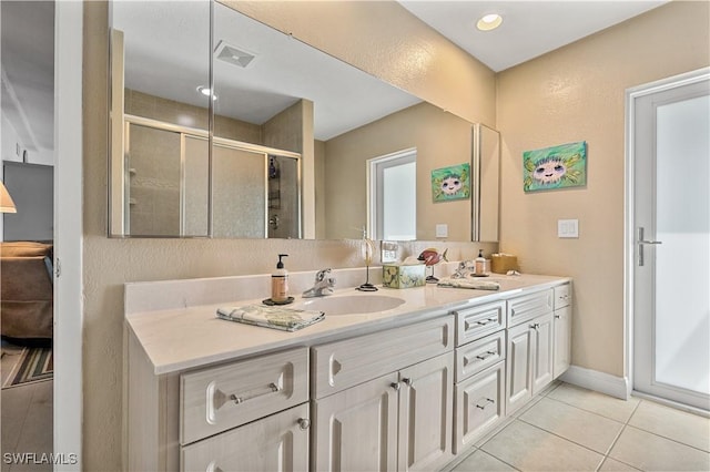 bathroom featuring vanity, tile patterned floors, and walk in shower