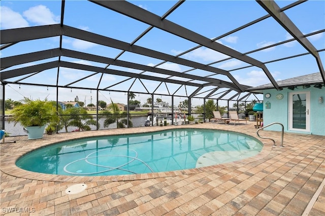 view of pool with a lanai, a patio area, and a water view