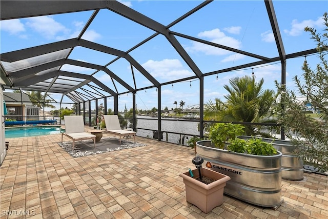 view of patio / terrace with a water view and a lanai