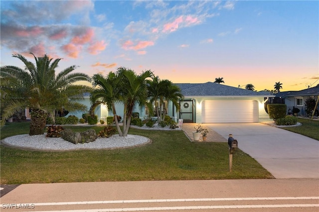 view of front of house with a garage and a lawn