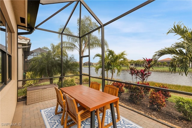 sunroom featuring a water view