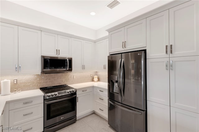 kitchen featuring appliances with stainless steel finishes, white cabinets, and decorative backsplash