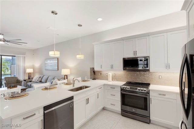 kitchen featuring pendant lighting, sink, kitchen peninsula, and appliances with stainless steel finishes