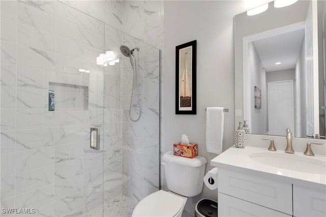 bathroom featuring vanity, toilet, and a shower with door