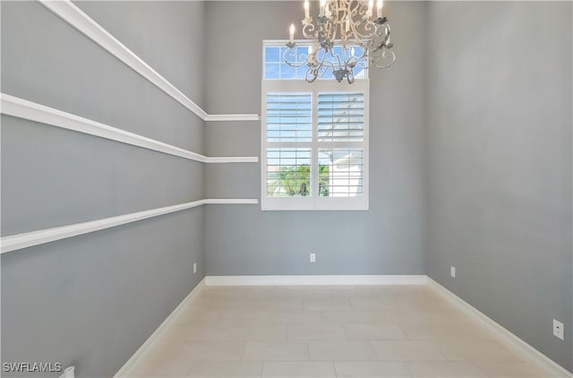 unfurnished room with a chandelier