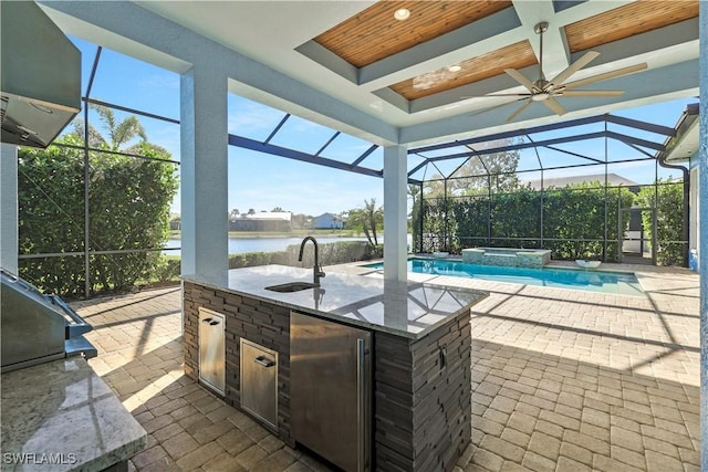 interior space with a water view, exterior kitchen, a lanai, a pool with hot tub, and a wet bar