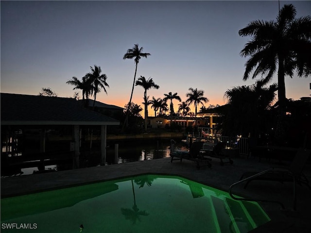 outdoor pool featuring a patio area and a water view