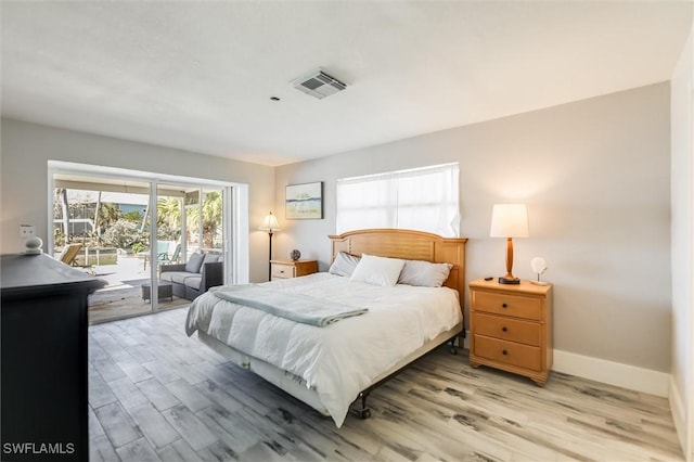 bedroom with access to exterior, visible vents, light wood-style floors, and baseboards