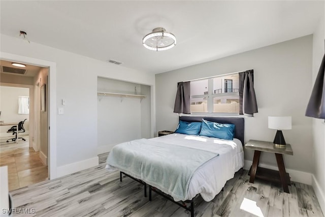 bedroom with baseboards, visible vents, and a closet