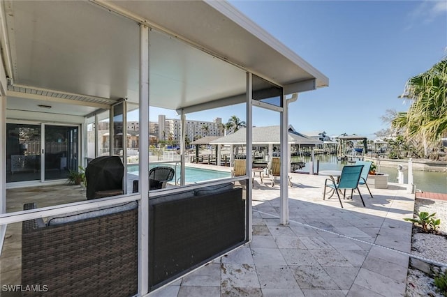 view of patio featuring grilling area, a water view, and an outdoor pool