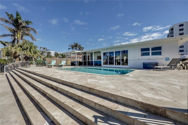 view of swimming pool featuring a patio area, fence, and a fenced in pool