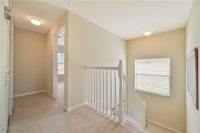 hall with light colored carpet