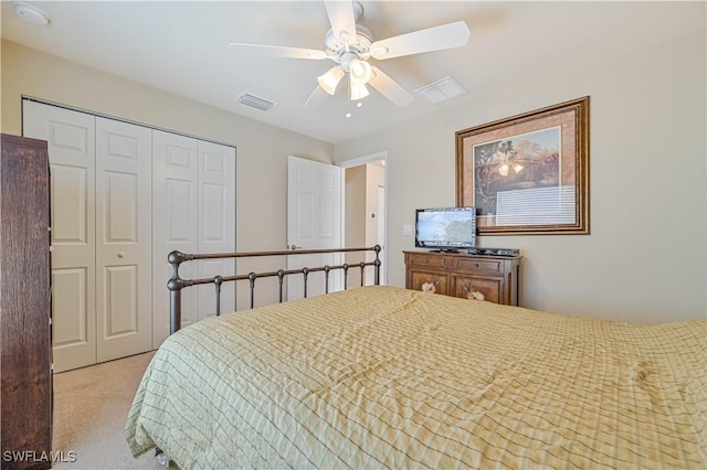 bedroom with a closet, ceiling fan, and light colored carpet