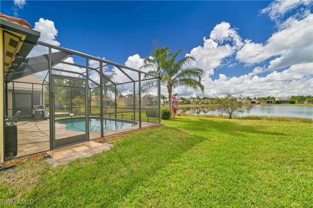 view of yard featuring glass enclosure, a patio area, and a water view