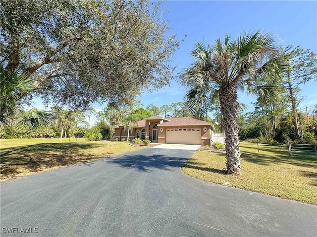 view of front of house featuring a garage and a front lawn