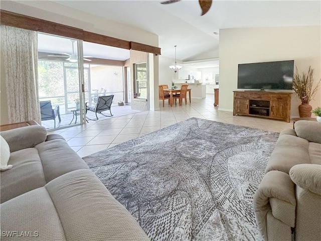 tiled living room with lofted ceiling and ceiling fan with notable chandelier