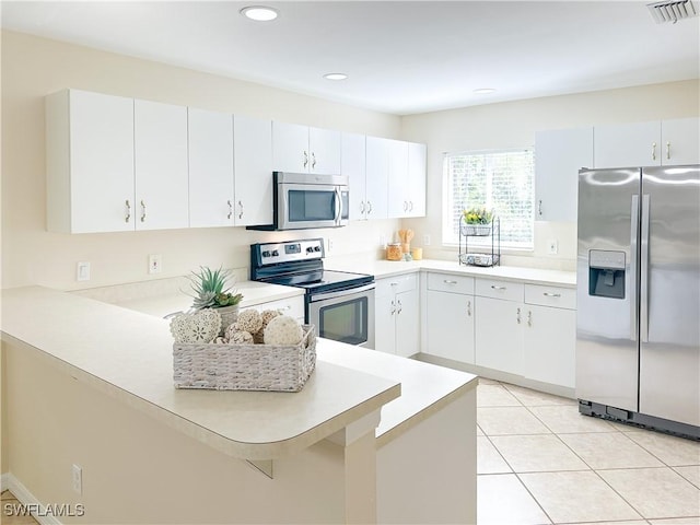 2910 2nd St NE, Naples, FL 34120 - kitchen featuring stainless steel appliances, light countertops, a peninsula, recessed lighting, and light tile patterned flooring