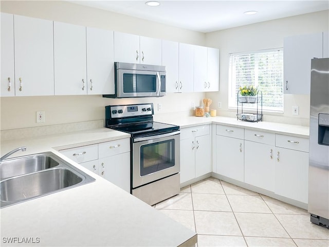 2910 2nd St NE, Naples, FL 34120 - kitchen with stainless steel appliances, a sink, light countertops, white cabinetry, and recessed lighting
