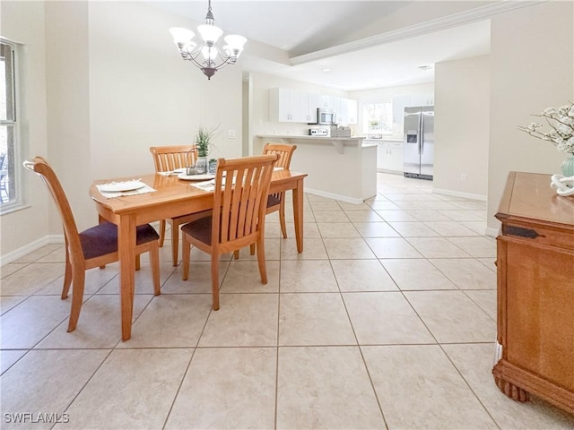 dining space with light tile patterned flooring and an inviting chandelier