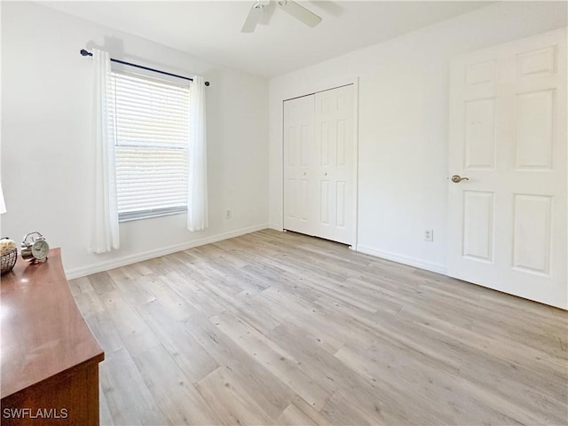 2910 2nd St NE, Naples, FL 34120 - unfurnished bedroom featuring light wood-style flooring, a closet, ceiling fan, and baseboards