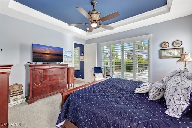 bedroom with ceiling fan, carpet, a tray ceiling, and crown molding