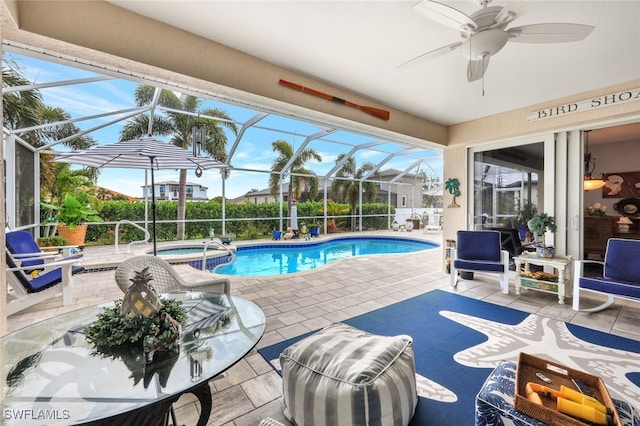 view of pool with glass enclosure, a patio area, an in ground hot tub, and ceiling fan