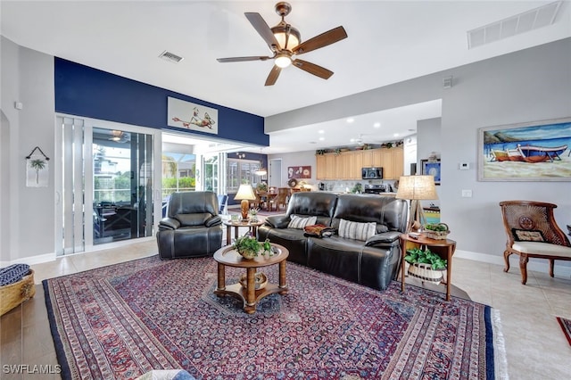 living area featuring ceiling fan, light tile patterned flooring, visible vents, and baseboards