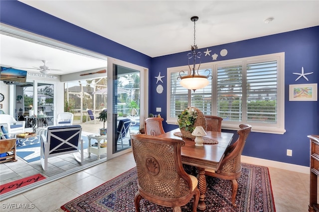 dining area featuring light tile patterned floors, ceiling fan, and baseboards