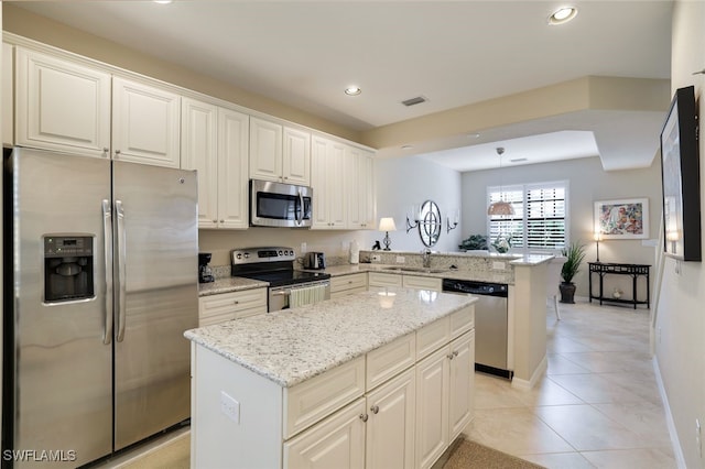 kitchen featuring white cabinetry, a kitchen island, kitchen peninsula, and appliances with stainless steel finishes