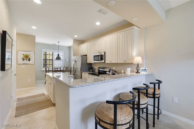 kitchen featuring pendant lighting, light tile patterned floors, appliances with stainless steel finishes, light stone counters, and kitchen peninsula