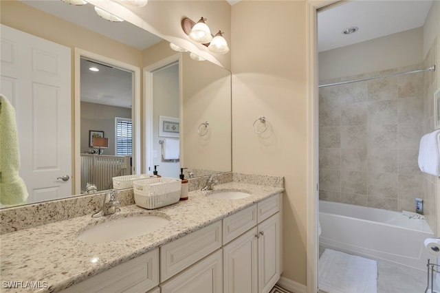 bathroom featuring vanity and tiled shower / bath