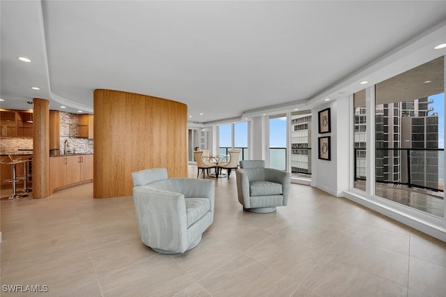 tiled living room featuring expansive windows and sink