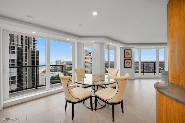 tiled dining room featuring a wall of windows and plenty of natural light