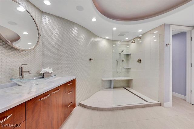 bathroom with vanity, tile patterned flooring, and a tile shower